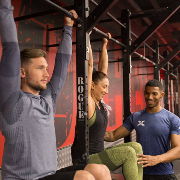 Trainer coaching on pull-up abs exercise Trainer coaching on pull-up abs exercise