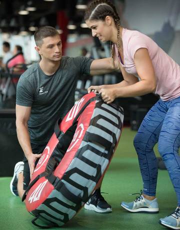 Coach instructing a member on wheel flip exercise