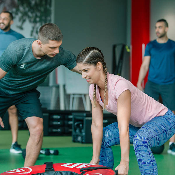 personal trainer teaching on wheel flip exercise personal trainer teaching on wheel flip exercise