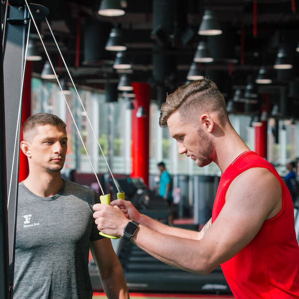 Personal trainer coaching on triceps pull-down exercise Personal trainer coaching on triceps pull-down exercise