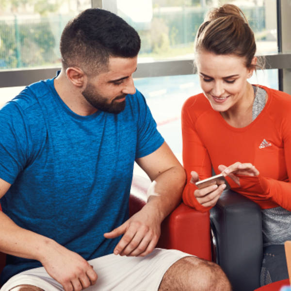 Man and woman using "my Fitness First" app Man and woman using "my Fitness First" app