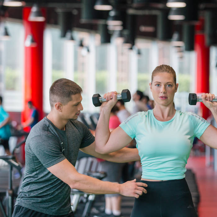 personal trainer coaching on dumbbells lifting personal trainer coaching on dumbbells lifting