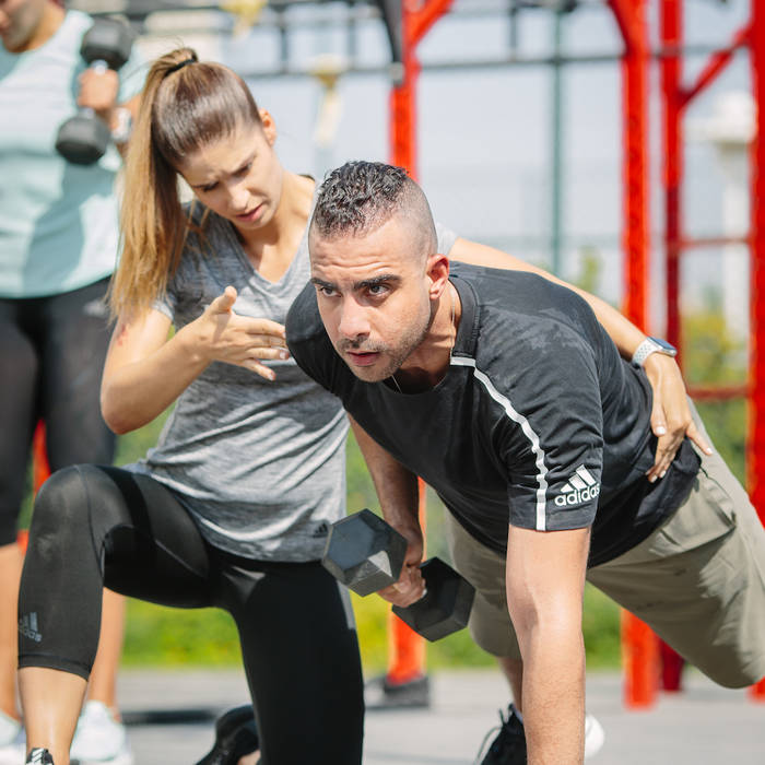 Personal trainer coaching on single arm dumbbell row Personal trainer coaching on single arm dumbbell row