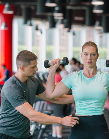 personal trainer coaching on dumbbells lifting