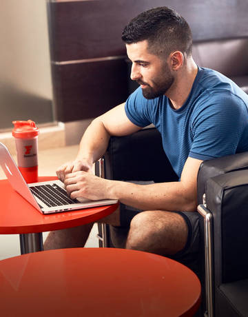 Fitness first member using his laptop in the lounge